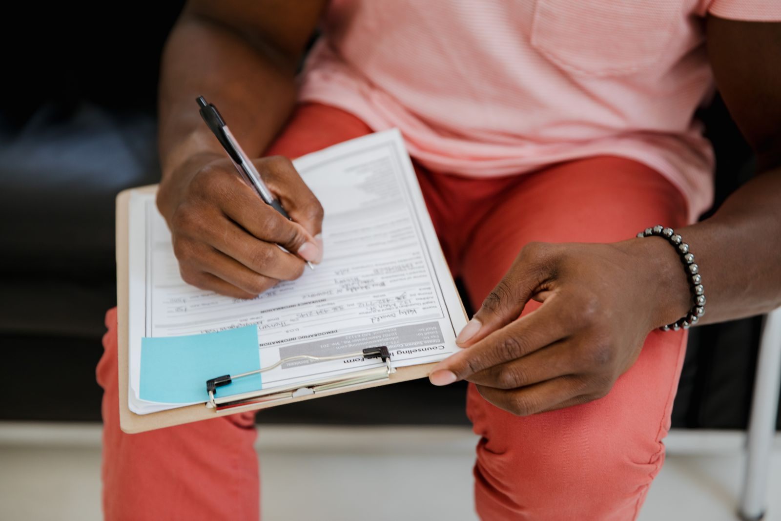 A traveller filling in a printed form on a clipboard, like a post cruise guest satisfaction survey